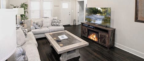 living area with smart TV and fireplace in TV stand.  Video arcade system.