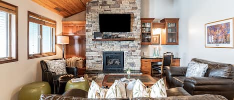 Living Room with leather couches, gas fireplace, smart TV & work desk