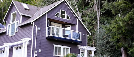 The house is tucked amongst old-growth trees.