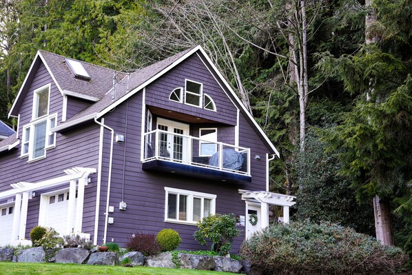 The house is tucked amongst old-growth trees.