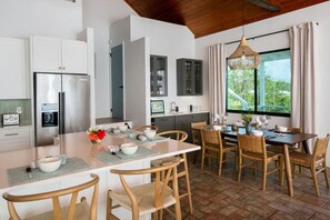 Kitchen opens to dining area and wet bar with a view towards to the back patio