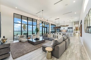 Oceanfront great room with vaulted ceilings, modern furniture and decor. 