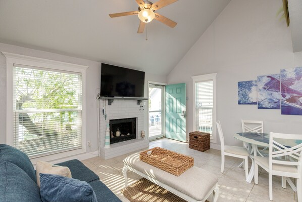 Bright and spacious living area with flat screen TV and large windows