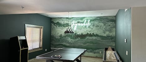 Game room with ping pong, arcade game, and shuffleboard