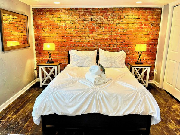 This suite has 2 bedrooms. The exposed brick in this bedroom creates a rustic vibe. 
