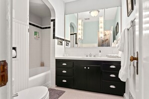 Luxurious and timeless full bath on the main floor featuring stunning marble counters, tile floors and a tub/shower combo.