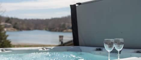 Unwind and soak up serenity: experience blissful relaxation in our lakeside hot tub with breathtaking views of Lake Brittany in Bella Vista, AR.