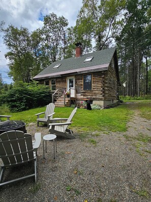 Side yard with firepit and Adirondack chairs