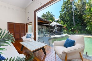 The living are fronts the deck and sparkling pool, with wall-to-wall sliding doors that invite  the coastal breezes to roll through.