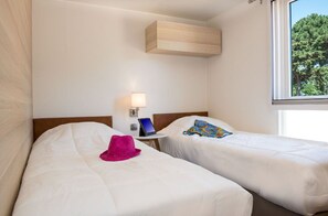 Comfortable twin bedroom with simple, elegant decor, providing a peaceful space to relax.