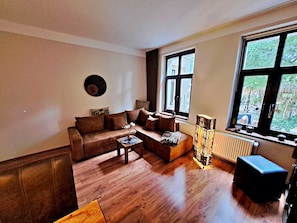 Wohnbereich mit Couch, TV und Esstisch