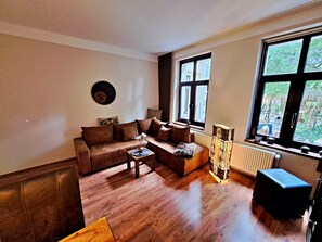Wohnbereich mit Couch, TV und Esstisch