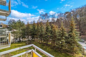 A balcony view showcasing lush green trees and a scenic outdoor area.
