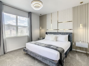 Rest and comfort in a room with a queen bed, flat-screen TV, and large windows.