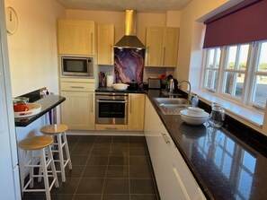 Fully fitted kitchen with breakfast bar, dishwasher, washing machine and cookers
