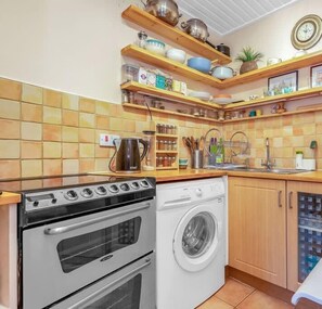 Fully-equipped kitchen with hob, oven, washer, dishwasher, coffee maker and cookware