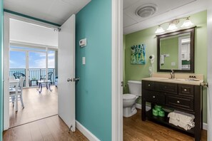 Bright and inviting bathroom with modern fixtures and a coastal flair! Just steps away, enjoy the open floor plan leading to breathtaking ocean views from the balcony. 