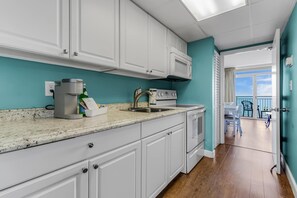 Prepare meals with ease in this fully equipped kitchen featuring sleek countertops, modern appliances, and a charming coastal vibe. Steps away from stunning ocean views to enhance your beach retreat!