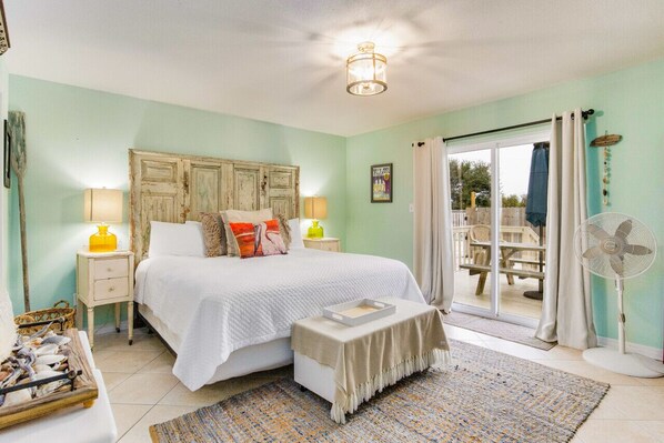 Bedroom with a private patio accessed through sliding glass doors.