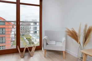A cozy armchair near the window, perfect for enjoying natural light while reading or relaxing.
