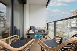 A balcony with rattan chairs and a scenic view, perfect for relaxation.
