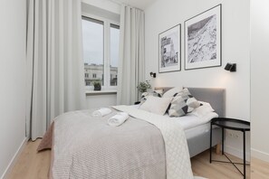 A comfortable bedroom with a large bed, neutral tones, and soft lighting.