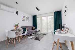 A dining area with a round table, white chairs, and fresh flowers, offering a bright and inviting space.
