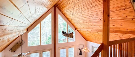 The living room space from the loft overlooking nature through the floor to ceiling windows. Very open and airy!