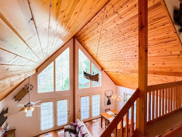 The living room space from the loft overlooking nature through the floor to ceiling windows. Very open and airy!