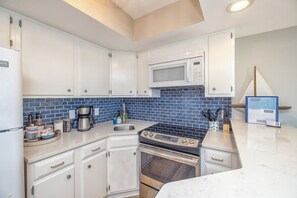 The updated kitchen is tiny but mighty! Full size appliances and fully stocked.