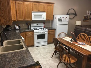 Full size kitchen with fridge, stove, microwave, dishwasher, table seats 6