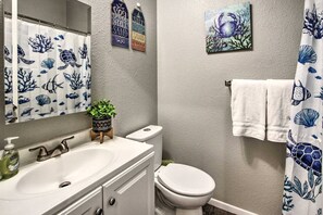 Bathroom featuring sink vanity and essentials such as towels, shampoo, body wash