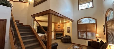 A huge vaulted ceiling and large bright windows grace this large living room space with 65" smart TV, Fireplace and oversized mountain leather couches and love seats.