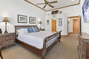 A spacious master bedroom with massive vaulted ceiling, large smart TV, Plush sleigh bed, sitting area and private patio is the perfect retreat after a great day of outdoor fun in Midway