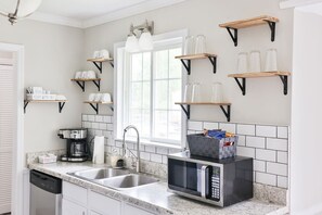 Lots of wall shelving in the kitchen to hold all the glasses and coffee mugs