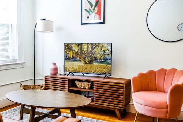 Spacious Living Room with Sofa, Smart TV, and Lounge Chair. 