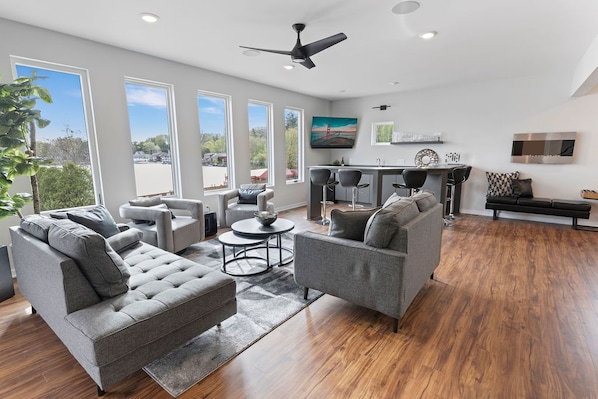 Main floor living room/bar area with amazing floor to ceiling lake views!