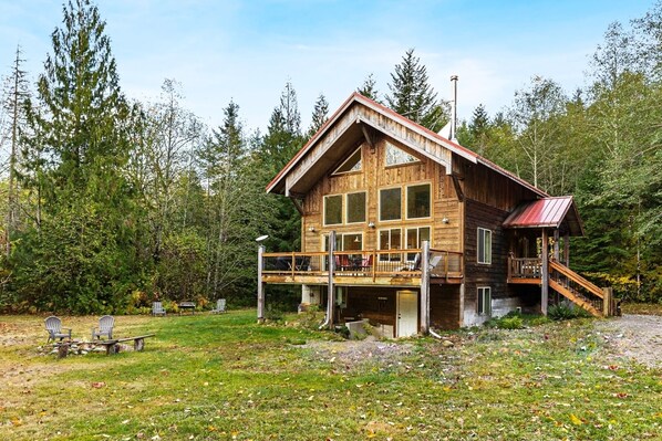 Exterior view of the house, looking at the raised deck and entryway on the right