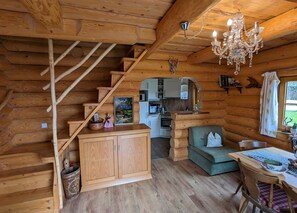 Ferienwohnung I - Hirsch-Schloßalm Wohnraum mit Küche und Treppe in den 1. Stock