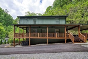 Exterior of cabin with four car parking and wrap around deck.