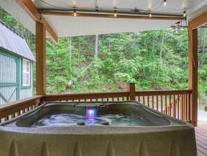 Four person hot tub with massaging jets with a beautiful view with additional roller shades to provide privacy. 