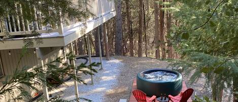 View of the backyard and deck above, from the trees surrounding the chalet.