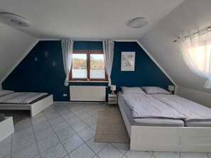 Schlafzimmer mit Doppelbett und 2 Einzelbetten