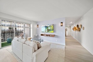 Living room with TV, sofa bed, and balcony