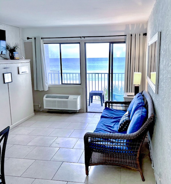 Living room with a balcony and beach front view.