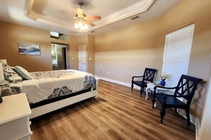The primary bedroom has a queen bed and there is a sitting area 