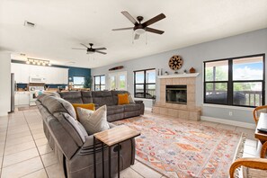 Main living room with lots of seating, reclining couch, wood burning fireplace