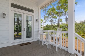 Front porch with exquisite glass window doors and hightop table and chairs.