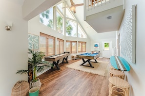 Game room with pool, shuffleboard, foosball, and a surfboard bar. 