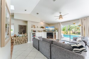 Living room with large sectional sofa, electric fireplace, and 58" smart TV.